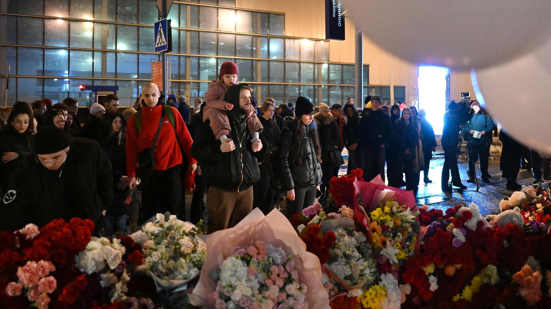 Люди у стихийного мемориала возле Крокус Сити Холла в память о жертвах теракта - РИА Новости, 1920, 24.03.2024