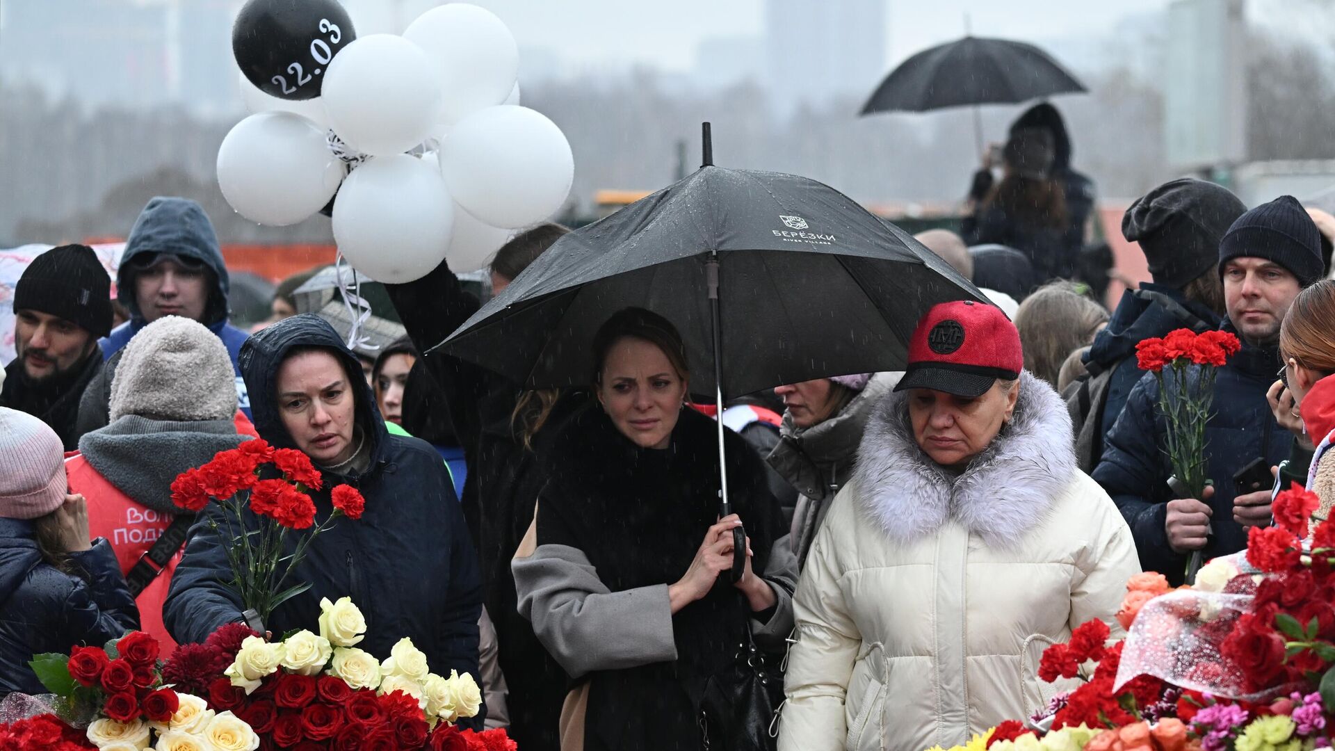 Люди возлагают цветы к стихийному мемориалу возле подмосковного Крокус Сити Холла в память о жертвах теракта - РИА Новости, 1920, 25.03.2024