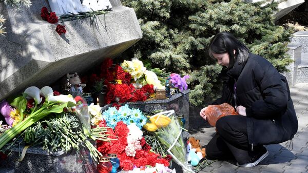 Девушка кладет мягкие игрушки к стихийному мемориалу в Комсомольском парке в Севастополе во время акции в память о жертвах теракта в подмосковном Крокус Сити Холле3