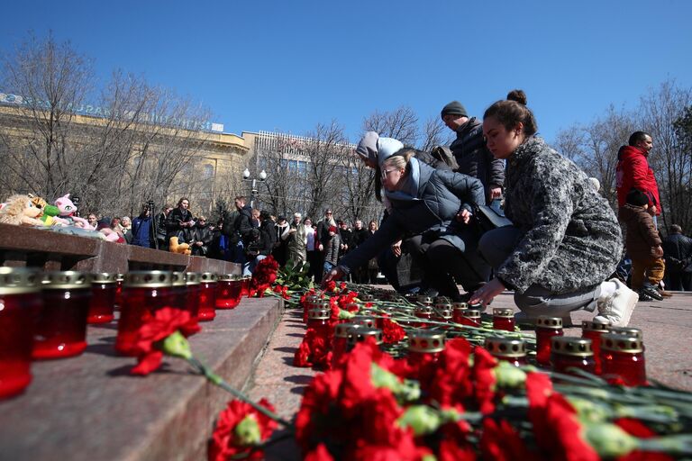 Люди возлагают цветы к стихийному мемориалу возле памятника героям обороны Красного Царицына в Волгограде в память о жертвах теракта в подмосковном Крокус Сити Холле