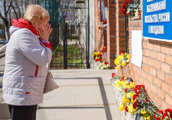 Женщина у стихийного мемориала возле российского консульства в Тирасполе во время акции в память о жертвах теракта в подмосковном Крокус Сити Холле