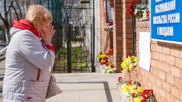 Женщина у стихийного мемориала возле российского консульства в Тирасполе во время акции в память о жертвах теракта в подмосковном Крокус Сити Холле8