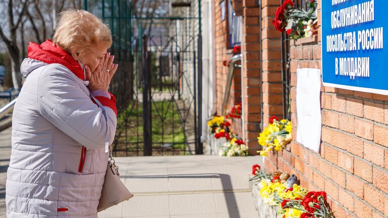 Женщина у стихийного мемориала возле российского консульства в Тирасполе во время акции в память о жертвах теракта в подмосковном Крокус Сити Холле