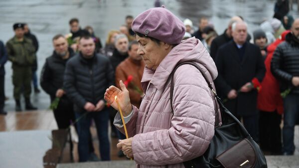 Женщина у стелы Владивосток - город воинской славы во время акции в память о жертвах теракта в подмосковном Крокус Сити Холле
