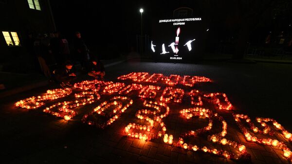 Люди зажигают свечи памяти в Донецке в день общенационального траура по погибшим в результате теракта в подмосковном Крокус Сити Холле