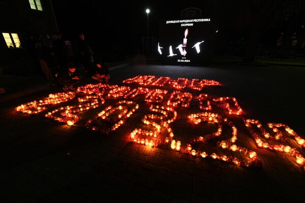Люди зажигают свечи памяти в Донецке в день общенационального траура по погибшим в результате теракта в подмосковном Крокус Сити Холле