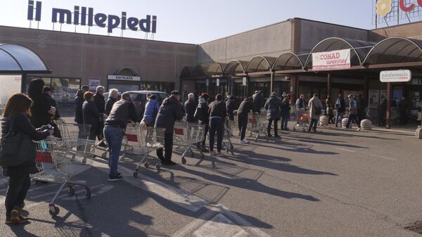 Люди стоят в очереди возле супермаркета в Италии
