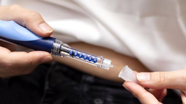 Девушка делает инъекцию инсулина при помощи шприц-ручки
