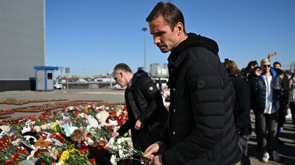 Вратарь футбольного клуба Динамо Антон Шунин возлагает цветы к стихийному мемориалу возле подмосковного Крокус Сити Холла в память о жертвах теракта