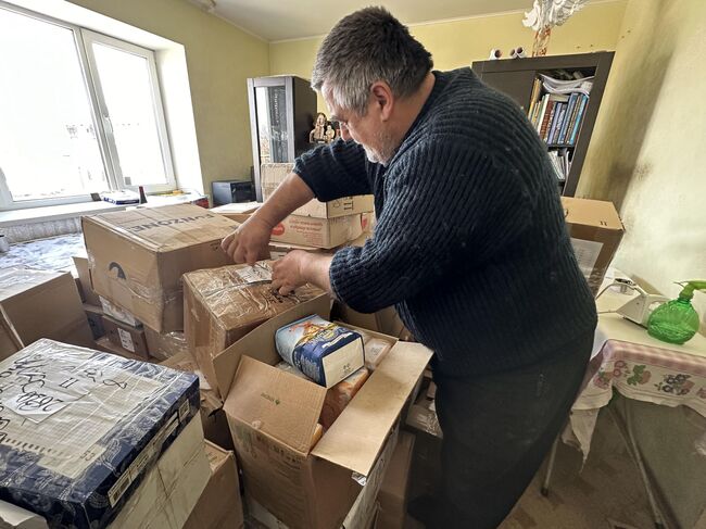 Александр Хоминец вскрывает посылки с гуманитаркой