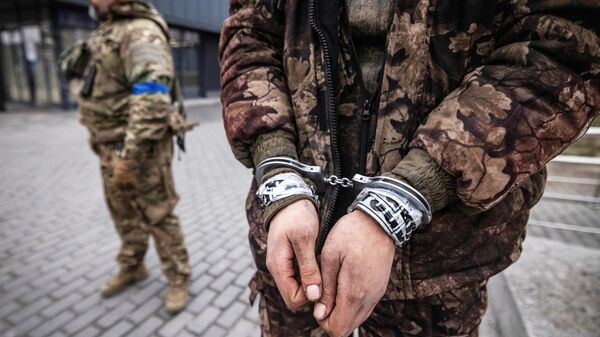 Украинский военнослужащий рядом с пленным российским военнослужащим