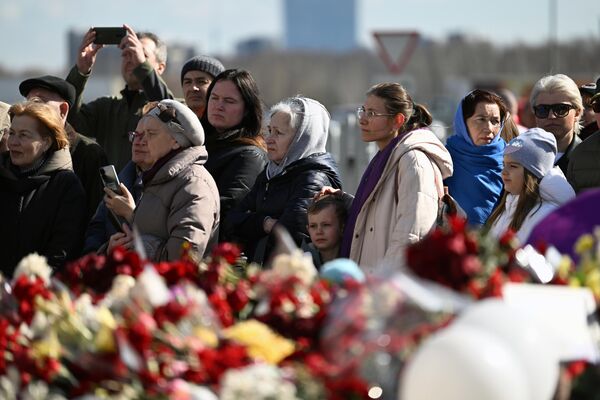 Люди у стихийного мемориала в память о жертвах теракта 22 марта 2024 г. в Крокус Сити Холле