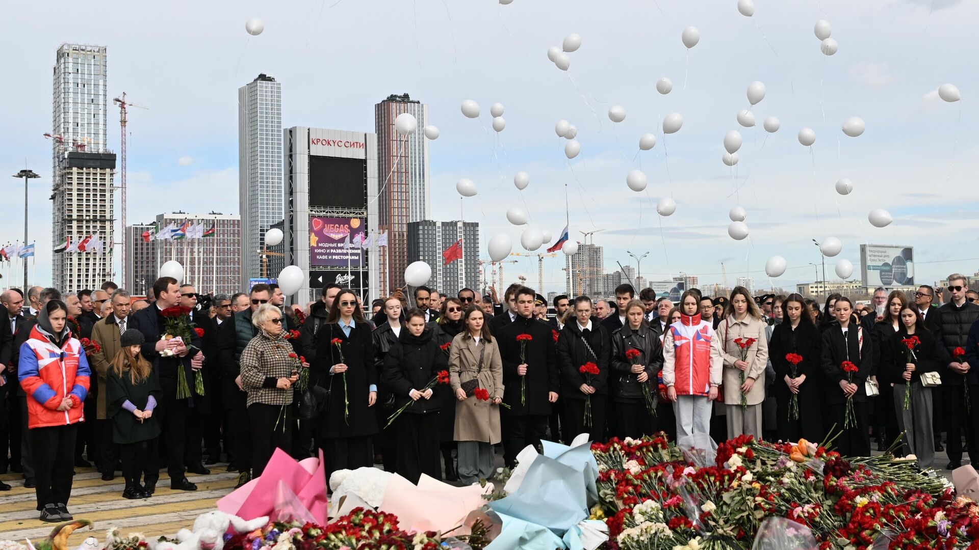 Люди запускают белые воздушные шары у стихийного мемориала в память о жертвах теракта в Крокус Сити Холле - РИА Новости, 1920, 30.03.2024