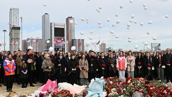 Люди запускают белые воздушные шары у стихийного мемориала в память о жертвах теракта в Крокус Сити Холле