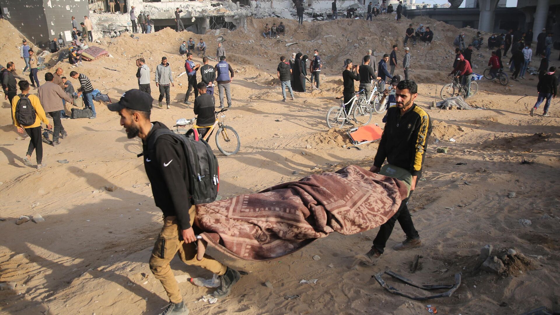 Палестинцы выносят тело из больницы Аш-Шифа в Газе после того, как израильские военные покинули ее территорию. 1 апреля 2024 - РИА Новости, 1920, 01.04.2024