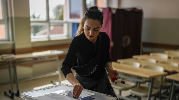 Женщина голосует на избирательном участке в Стамбуле, Турция