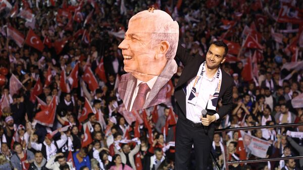 Мужчина держит портрет мэра Анкары Мансура Яваша, который набрал более 60% голосов на выборах в местные органы самоуправления