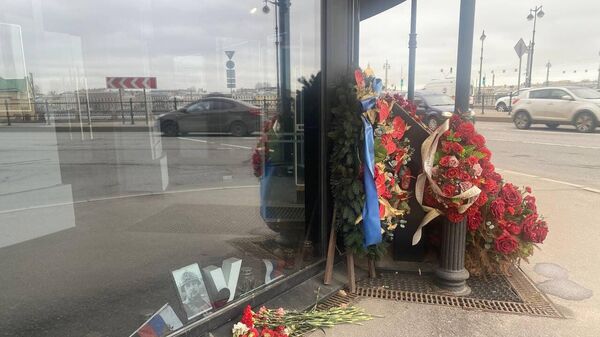 Цветы у кафе в Петербурге, где в результате теракта год назад погиб Владлен Татарский