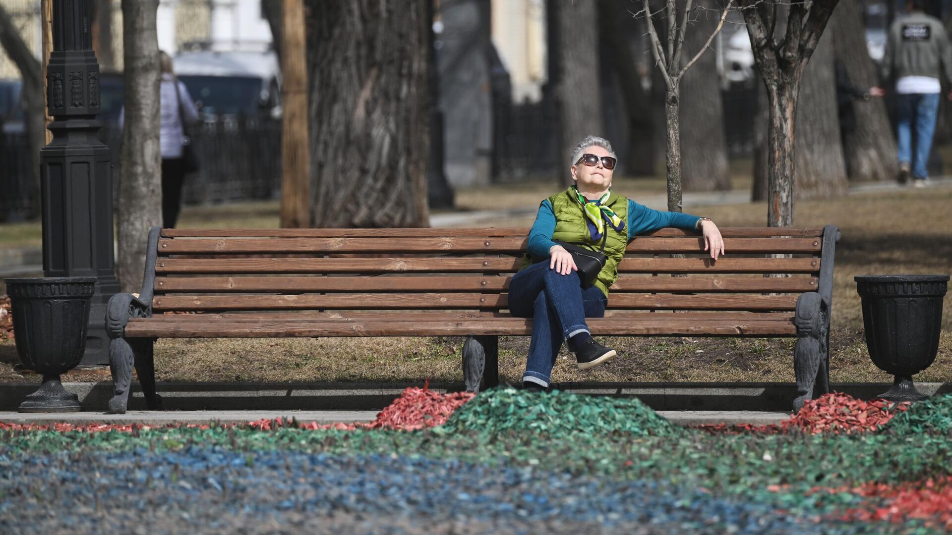 Женщина отдыхает на скамейке во время теплой погоды в одном из парков Москвы - РИА Новости, 1920, 06.04.2024