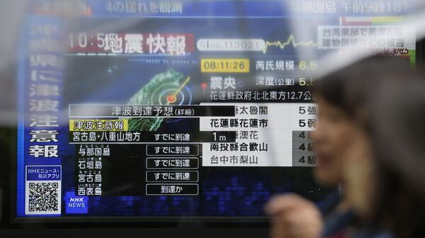 Экраны с новостями о цунами в регионе Окинавы и землетрясении вблизи Тайваня