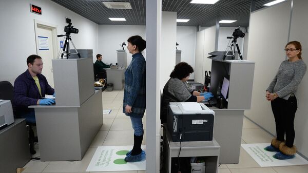 Иностранные граждане фотографируются в Едином миграционном центре Московской области