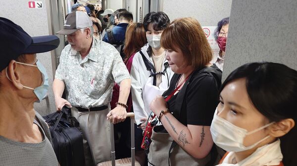 Люди заходят в поезд после восстановления движения в Тайбэе, Тайвань 
