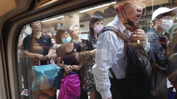 Пассажиры ждут посадки на поезд следующий на юг после восстановления движения в Тайбэе, Тайвань 