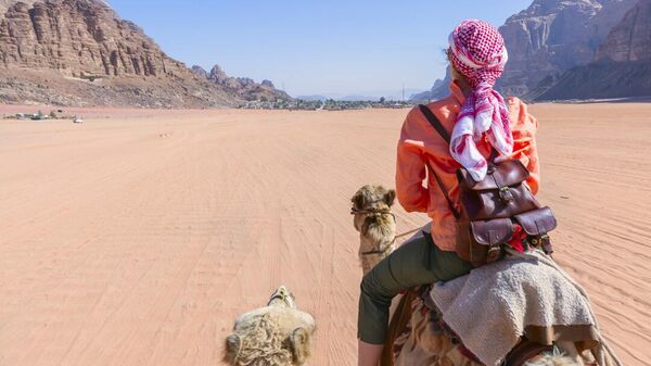 Туристка верхом на верблюде в пустыне Вади-Рам в Иордании
