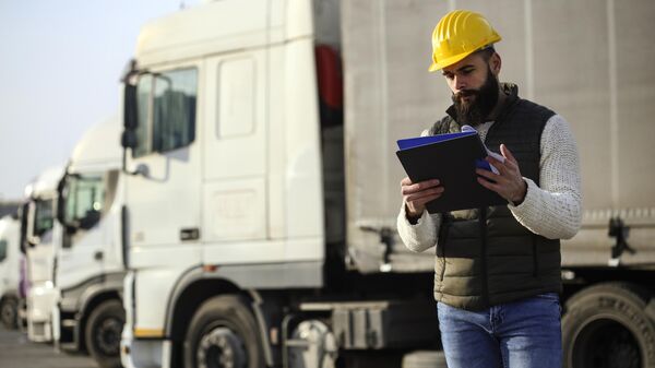 Мужчина проверяет документы на стоянке для грузовиков