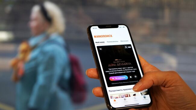 Экран смартфона с изображением сайта интернет-сервиса о кино Кинопоиск