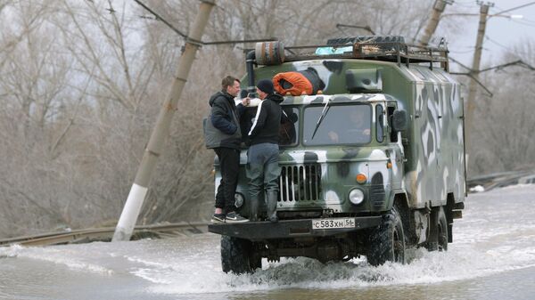 Машина, на которой жителей эвакуируют из затопленных после прорыва дамбы районов города Орска