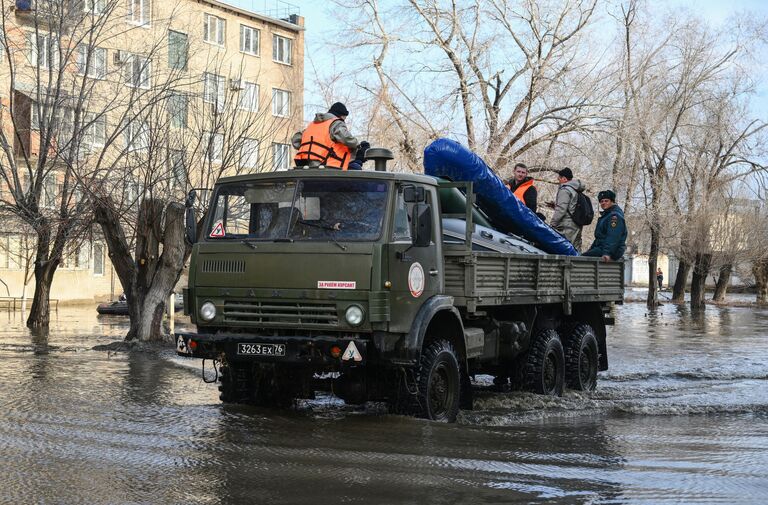 Спасатели подвозят лодки к затопленным из-за прорыва дамбы улицам в Орске для дальнейшей эвакуации жителей