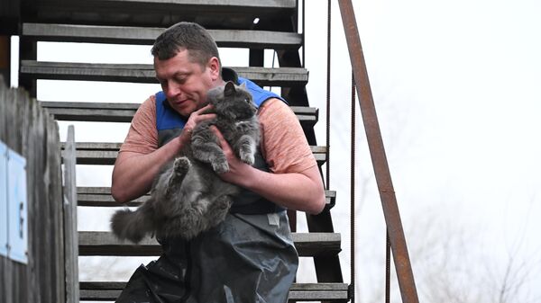 Мужчина эвакуирует кошку из затопленного дома в микрорайоне Форштадт в Оренбурге