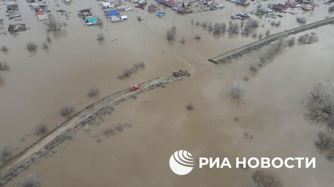 Рабочие засыпают дамбу в Орске