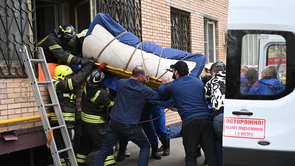 Спасатели выносят мужчину весом около 400 килограммов из квартиры в доме на Малой Калитниковской улице в Москве