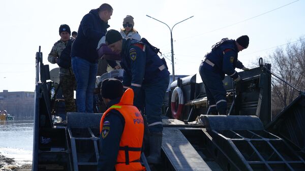 Волонтеры выходят на берег после рейса с МЧС на транспортере в зону затопления