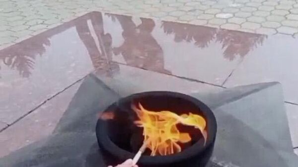Девятиклассница подкуривает сигарету от Вечного огня на площади Славы в Южно-Сахалинске