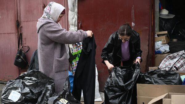 Женщина из затопленного района получает гуманитарную помощь, собранную для людей, пострадавших в результате прорыва дамбы, на улице Степана Разина в Оренбурге
