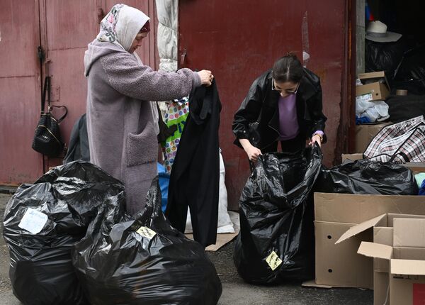 Женщина из затопленного района получает гуманитарную помощь, собранную для людей, пострадавших в результате прорыва дамбы, на улице Степана Разина в Оренбурге