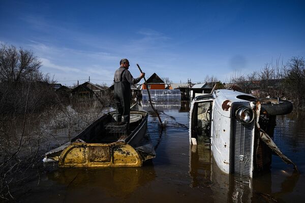 Мужчина передвигается на своей лодке по затопленному участку в Оренбурге