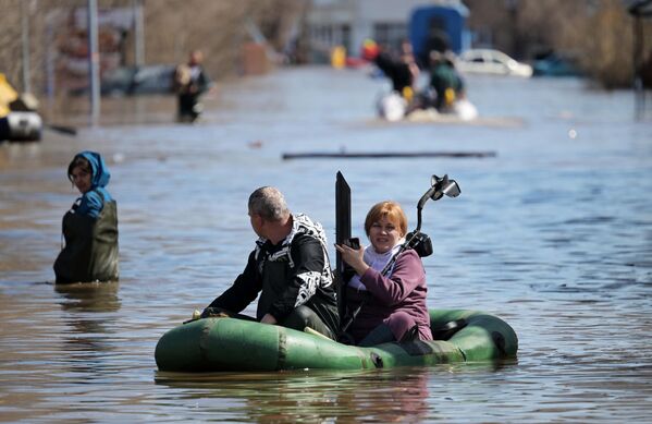 Местные жители в лодке на затопленной улице в Оренбурге