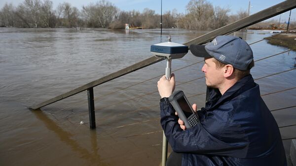 Сотрудник Государственного гидрологического института измеряет уровень воды в реке Урал в Оренбурге