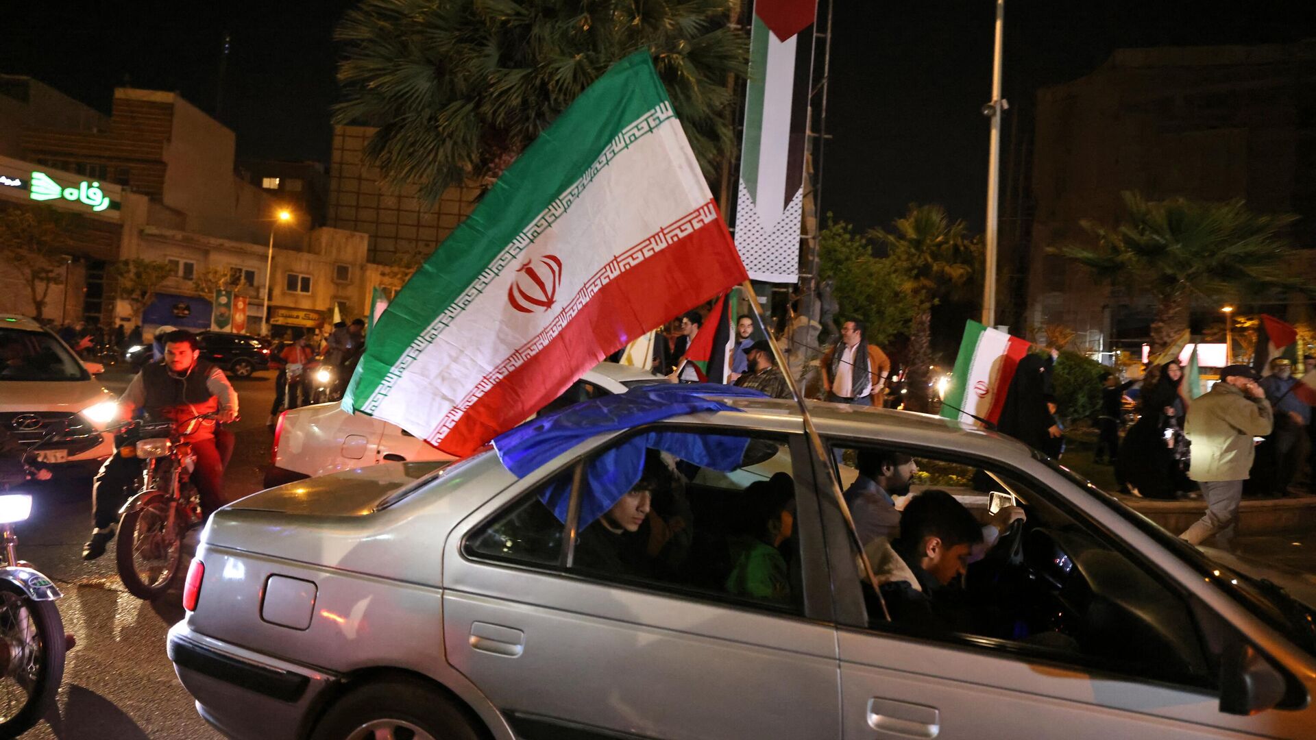 Демонстранты с флагами Ирана и Палестины на площади в центре Тегерана отмечают ночную воздушную атаку на Израиль со стороны Ирана. 14 апреля 2024 - РИА Новости, 1920, 14.04.2024