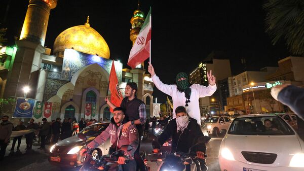 Демонстранты с флагами Ирана и Палестины на площади в центре Тегерана отмечают ночную воздушную атаку на Израиль со стороны Ирана. 14 апреля 2024