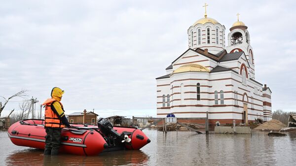 Местный житель передвигается на надувной лодке по затопленной улице Геннадия Донковцева в Оренбурге. 14 апреля 2024