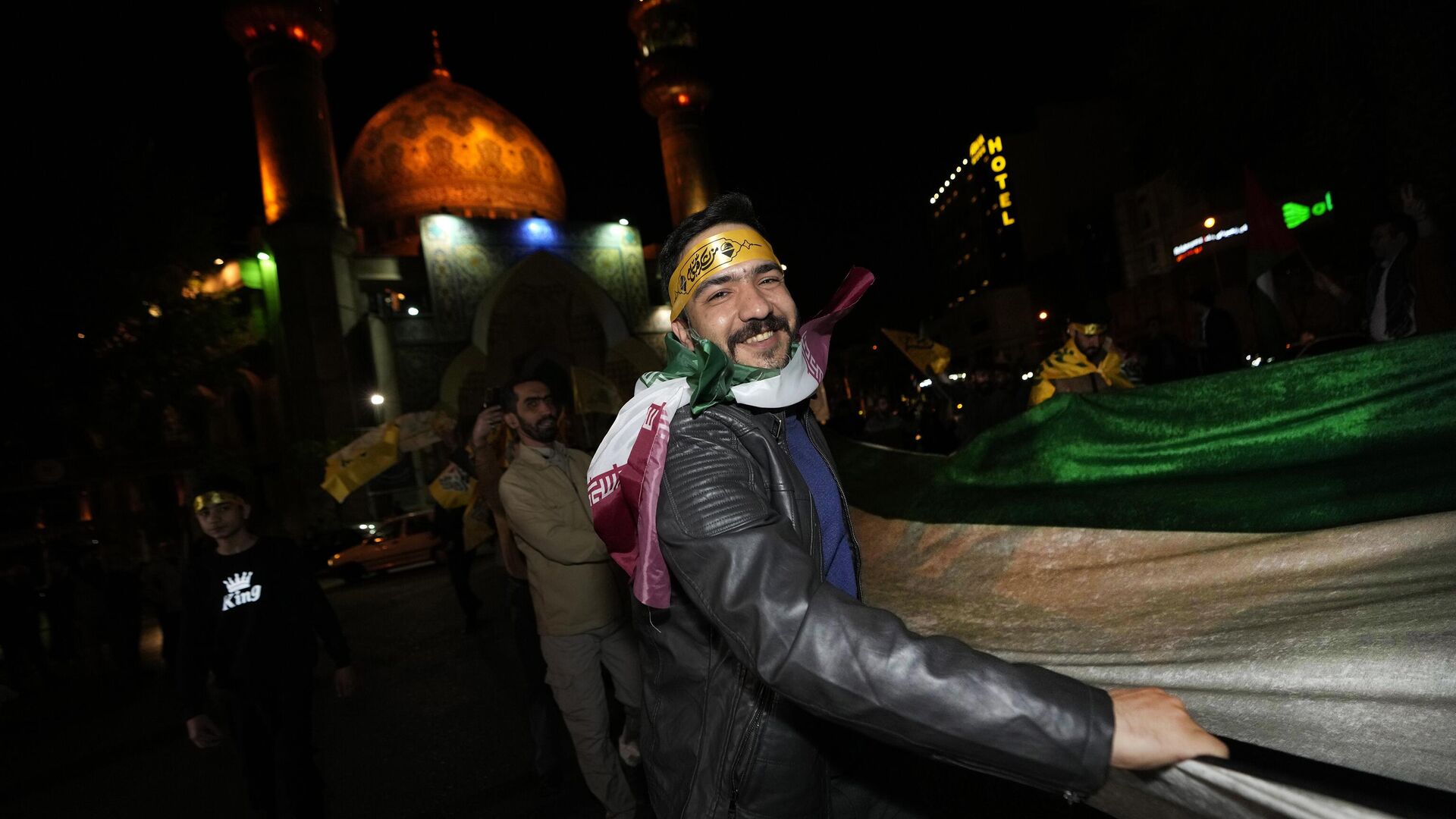 Демонстранты несут полотно в цветах иранского флага во время демонстрации в поддержку ночной атаки со стороны Ирана на Израиль. 14 апреля 2024 - РИА Новости, 1920, 14.04.2024