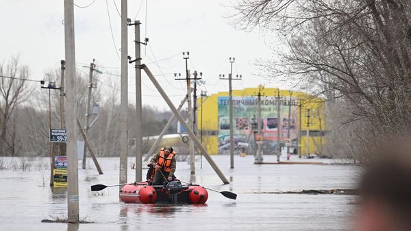 Местные жители передвигаются на надувных лодках по затопленной улице Геннадия Донковцева в Оренбурге. 14 апреля 2024