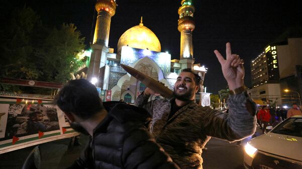 Мужчина с муляжом военного боеприпаса реагирует на ночную воздушную атаку на Израиль со стороны Ирана. 14 апреля 2024