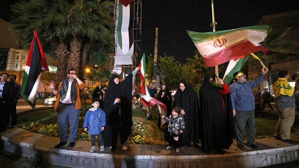 Демонстранты с флагами Ирана и Палестины на площади в центре Тегерана отмечают ночную воздушную атаку на Израиль со стороны Ирана