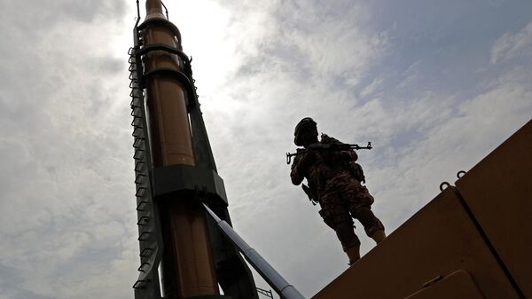 Иранский военнослужащий стоит рядом с баллистической ракетой Шахаб-3 в Тегеране, Иран